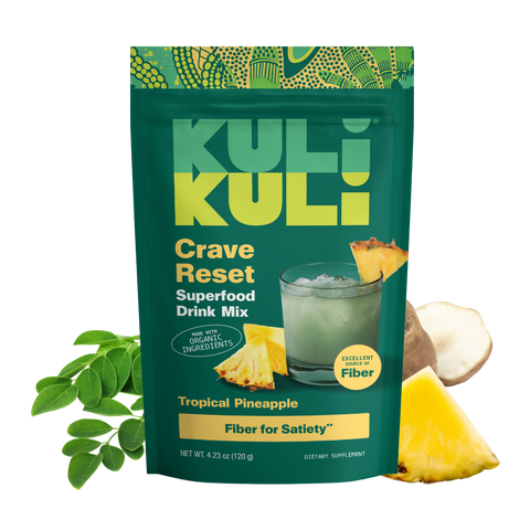 Kuli Kuli Crave Reset Superfood Drink Mix pouch in Tropical Pineapple flavor, surrounded by moringa leaves, Jerusalem artichoke, and pineapple.