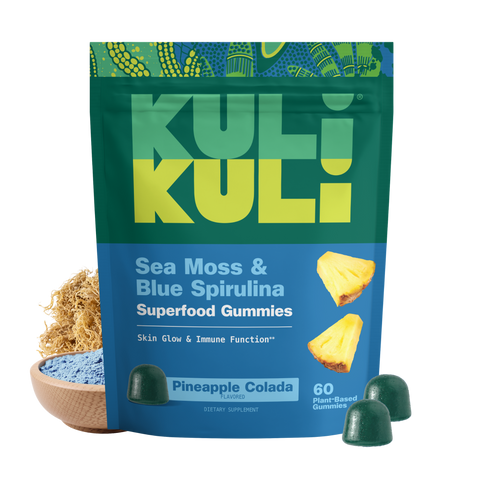 Kuli Kuli Sea Moss & Blue Spirulina Superfood Gummies pouch in Pineapple Colada flavor, shown with dark green gummies, dried sea moss, and a bowl of blue spirulina powder.