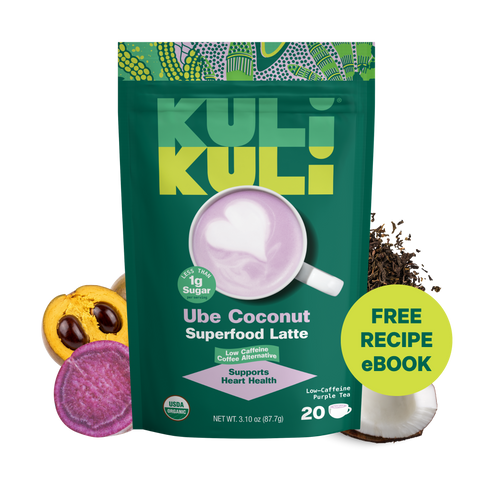 Kuli Kuli Ube Coconut Superfood Latte pouch with a purple latte and heart foam art, surrounded by lucuma, ube, purple tea leaves, and coconut. Badges read Less Than 1g Sugar, Supports Heart Health, Low Caffeine Coffee Alternative, USDA Organic, and Free Recipe eBook.